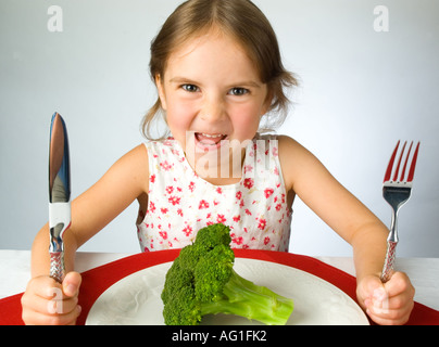 Ragazza giovane non è contento di dover mangiare broccoli Foto Stock