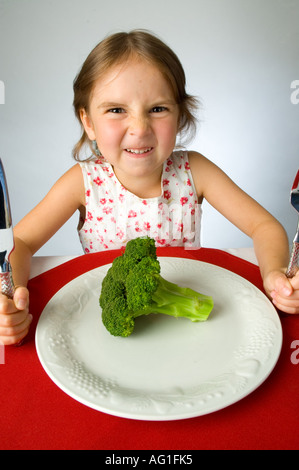 Ragazza giovane non è contento di dover mangiare broccoli Foto Stock