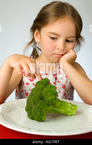 Ragazza giovane non è contento di dover mangiare broccoli Foto Stock