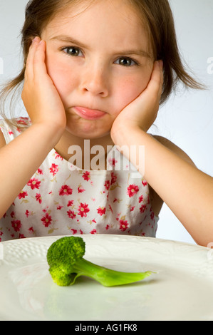 Ragazza giovane non è contento di dover mangiare broccoli Foto Stock