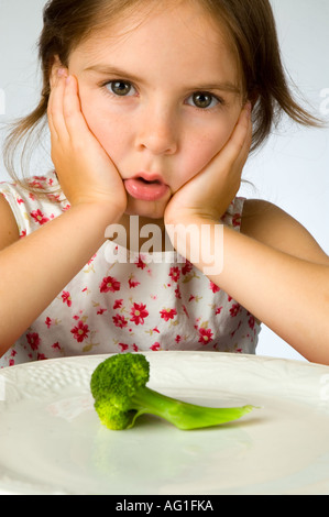 Ragazza giovane non è contento di dover mangiare broccoli Foto Stock