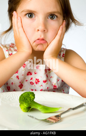 Ragazza giovane non è contento di dover mangiare broccoli Foto Stock