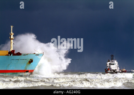 Naufragio di essere demolito da onde con i rimorchiatori in attesa Foto Stock