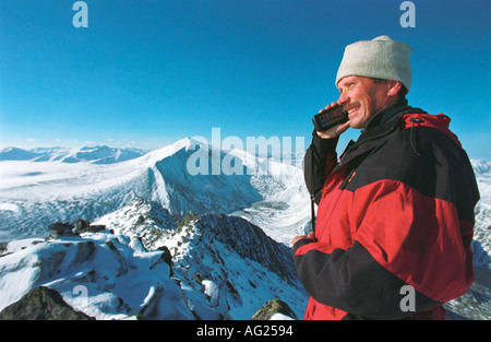 Un uomo sta parlando il telefono satellitare in monti Urali polari Russia Ural Narodnaya monte alto di montaggio Karpinsky Foto Stock