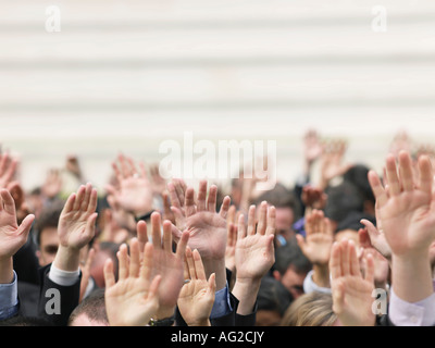 La folla di persone che allevano le mani, concentrarsi sulle mani Foto Stock