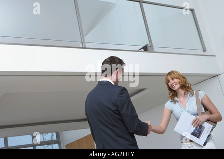 Agente immobiliare scuotendo mano di donna nuova casa Foto Stock