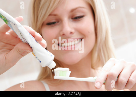 Giovane donna è spazzolare i denti con spazzolino da denti Foto Stock