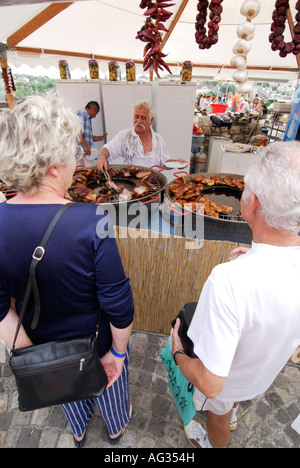 Clienti affamati di fronte di carne in enormi padelle festival di gastronomia Budapest Ungheria Europa Foto Stock