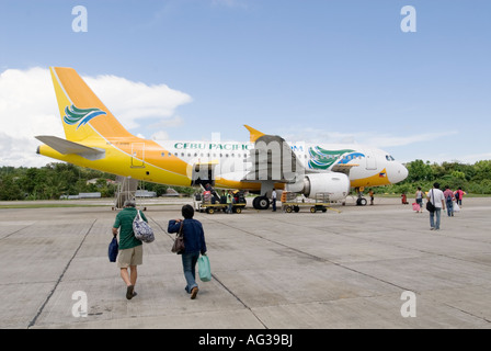 Passeggeri a piedi su asfalto a bordo di Cebu Pacifico Filippine In aereo Dall'Aeroporto di Tagbilaran Bohol Visayas Foto Stock