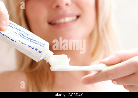 Giovane donna è spazzolare i denti con spazzolino da denti Foto Stock