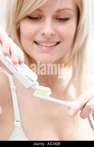 Giovane donna è spazzolare i denti con spazzolino da denti Foto Stock