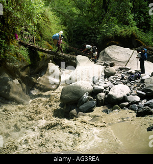 Facchini nella giungla attraversare un torrente sulla valle Myagdi Nepal Himalaya Asia Foto Stock