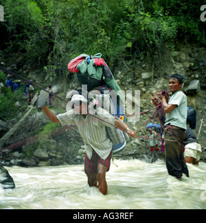 Facchini nella giungla attraversare un torrente sulla valle Myagdi Nepal Himalaya Asia Foto Stock