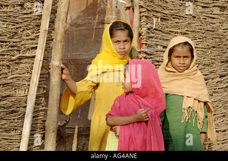 La vita del villaggio tre ragazza bambini indossare abiti di colore rosso giallo verde in škola Akot Maharashtra India Foto Stock