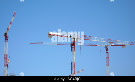 Il bianco e il rosso gru edili contro il cielo blu. Foto Stock