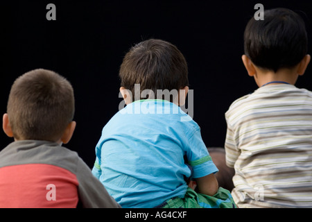 Vista posteriore di tre giovani ragazzi guardare il teatro di strada performance Gran Via Bilbao Pais Vasco Paese Basco in Spagna Foto Stock