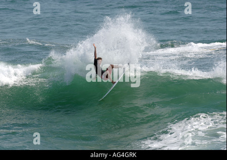 Un surfista eseguendo una manovra sulle onde in Huntington Beach California Foto Stock