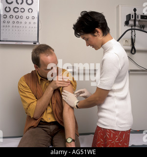 Medico è dare una iniezione di un paziente di sesso maschile Foto Stock