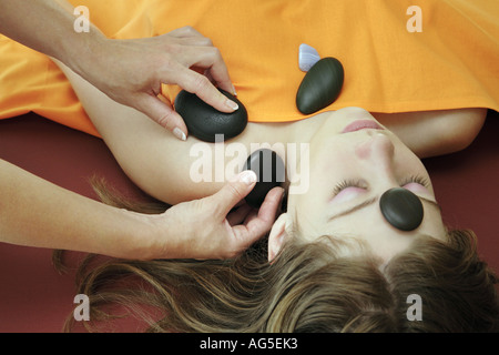 Giovane donna di ottenere un massaggio con pietre calde Foto Stock