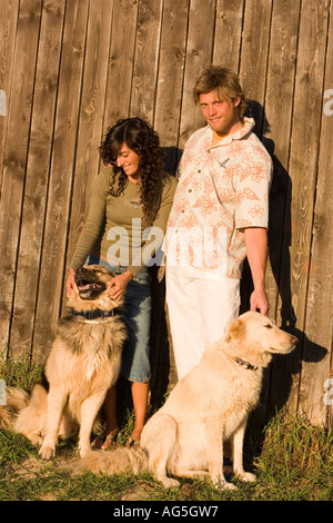 Un paio di godere il loro cane con recinto in legno sfondo Foto Stock
