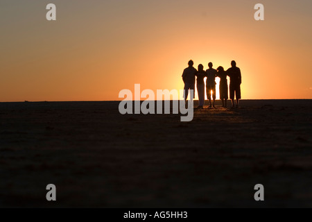 Gruppo di amici migliori tenendo le mani a piedi verso il tramonto Foto Stock