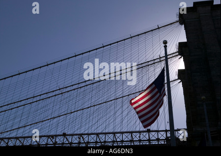 Un americano la bandiera a stelle e strisce Vola di fronte alla silhouette del Ponte di Brooklyn a New York City USA 2006 Foto Stock