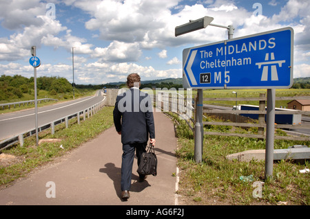 Un uomo cammina verso una giunzione autostradale sulla M5 REGNO UNITO Foto Stock