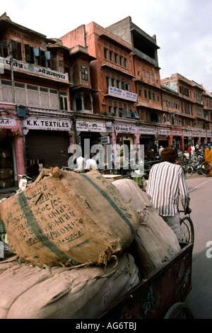 India Rajasthan Jaipur Johari Bazaar uomo tirando un carico pesante sul risciò ciclo Foto Stock