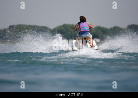 Due persone a cavallo di un jet ski. Foto Stock