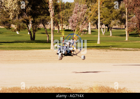 Un powered pilota di parapendio con un passeggero preparare alla terra Foto Stock