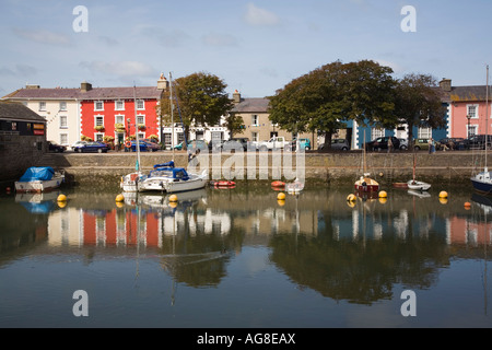 Coloratissime quayside case in stile georgiano si riflette nelle calme acque del porto con barche ormeggiate Aberaeron Galles Ceredigion REGNO UNITO Foto Stock