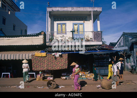 Donna che porta il bambino fuori negozio in strada con spazzatura, città di Duongdong; Phu Quoc, provincia di Kiên Giang, Vietnam, Asia Foto Stock