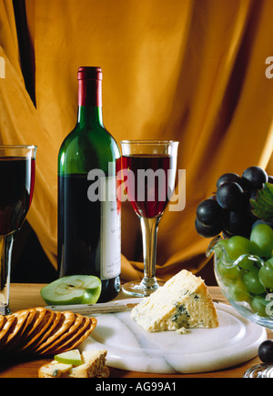 Bicchiere di vino rosso, del formaggio Stilton, bottiglia di vino e uva Foto Stock