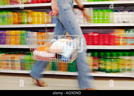 La donna che porta un carrello nel corridoio di un supermercato sezione bassa Foto Stock