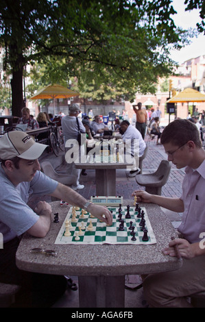 Le persone che giocano a scacchi in Harvard Square su tavole di pietra nella plaza di fronte all'Università di Harvard Cambridge MA Foto Stock