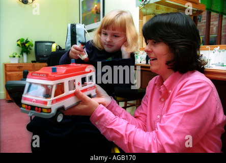 Terapista del gioco utilizzando la bambola e riprodurre una terapia per spiegare ai bambini malati come le iniezioni vengono somministrate. Foto Stock