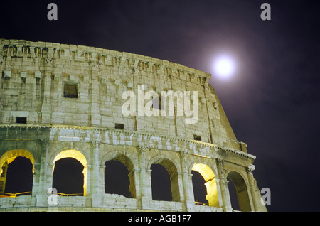Una vista notturna del Colosseo di Roma contro la luna piena Foto Stock