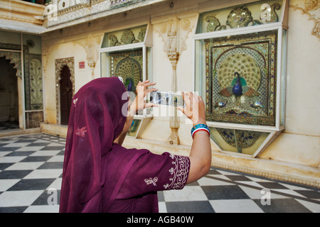 Donna indiana in splendidi sari di scattare una foto nel Complesso del City Palace in Udaipur India Foto Stock