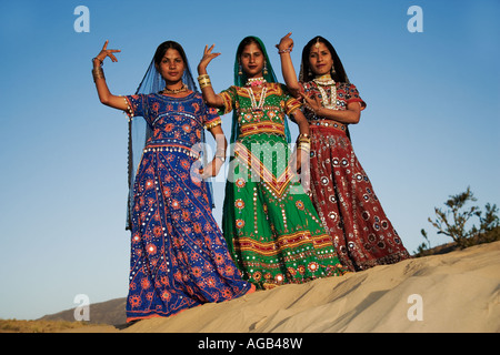 Giovani donne indiane in un splendidamente decorate sari eseguendo una tradizionale danza di Rajasthani deserto di Thar fuori Pushka India Foto Stock