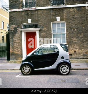 Una Smart auto parcheggiate al di fuori di una pietra casa a schiera con una porta rossa sulla fila di artiglieria West, Bunhill Row, Finsbury, London EC1, REGNO UNITO Inghilterra KATHY DEWITT Foto Stock