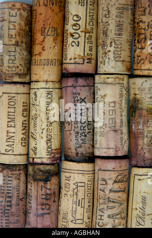 Una varietà di sugheri di vino francesi esposti insieme, con etichette provenienti da vigneti e anni diversi, che mostrano l'artigianalità Foto Stock