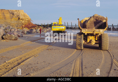 Mare repairng difese a happisburgh con rocce norfolk East Anglia England Regno Unito Foto Stock