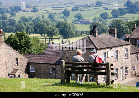 Due escursionisti seduta su una panchina di Reeth Swaledale Yorkshire Dales Inghilterra Foto Stock