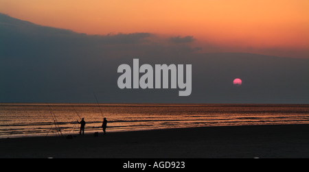 I pescatori di linee di impostazione per la pesca notturna su Tal y bont beach North Wales UK GB eu europe Foto Stock