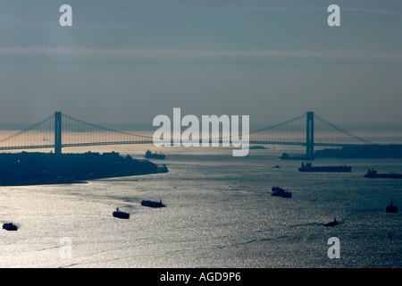 navi aeree di colpo navigano il porto della baia di new york sotto verrazano si restringe il ponte nella luce solare dorata degli stati uniti Foto Stock