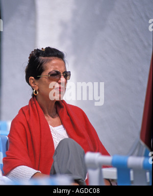 Donna capelli neri occhiali scuri scialle rosso Foto Stock