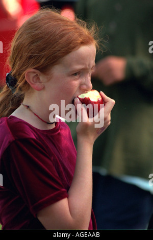 Girl Età 12 mangiare un apple dopo la scuola cattolica Bike-A-Thon. St Paul Minnesota USA Foto Stock