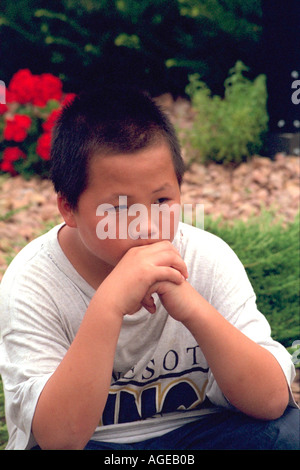 Contemplativa ragazzo asiatico età 9 in Laos i veterani di America protesta. St Paul Minnesota USA Foto Stock