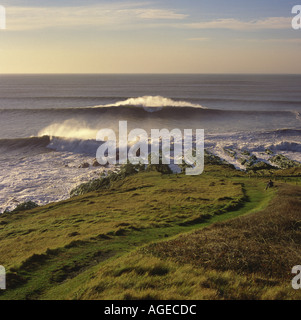 Surf di onde che si infrangono a Saunton Punto vicino Croyde Bay ha sottolineato da forti contra jour back lit sunshine North Devon England Foto Stock