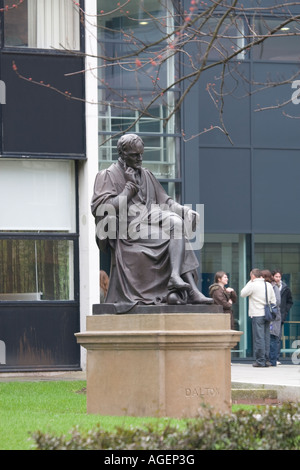 John Dalton statua fuori Manchester Metropolitan University s John Dalton edificio con studenti in background Foto Stock